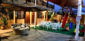 patio con mesa, sillas y parque infantil en Hotel Pousada Paradise, en Caraguatatuba