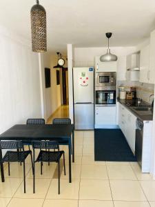Il comprend une cuisine équipée d'une table noire et d'un réfrigérateur. dans l'établissement Remote work Family holiday apartment, à Alcalá