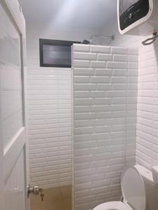 a white bathroom with a toilet and a shower at Casa de Gaudi Lembang in Lembang