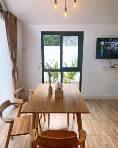 - une salle à manger avec une table et des chaises en bois dans l'établissement Casa de Gaudi Lembang, à Lembang