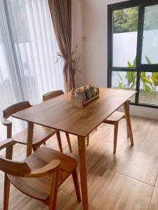 einen Holztisch und Stühle in einem Zimmer mit Fenster in der Unterkunft Casa de Gaudi Lembang in Lembang