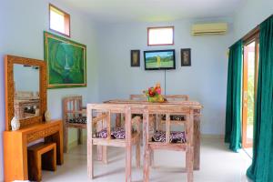 ein Esszimmer mit einem Holztisch und Stühlen in der Unterkunft Karauci Homestay in Abeansemal