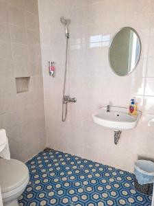 een badkamer met een toilet, een wastafel en een spiegel bij Rosemary Homestay in Batu