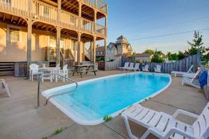 a swimming pool with white chairs and a house at Make My Day 710 in Avon
