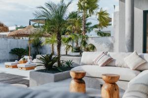 - un salon avec un canapé et des palmiers dans l'établissement Concrete Retreat Villa, à Canggu