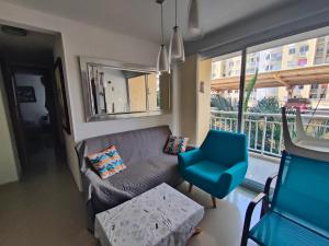 uma sala de estar com um sofá, uma cadeira e uma janela em Apto cómodo, confortable para descansar y Disfrutar em Cartagena de Indias