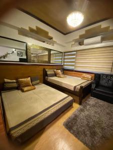 a bedroom with two beds and a rug at CedarPeak215 in Baguio