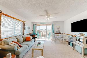 a living room with a couch and a flat screen tv at Oceanside Fun 952 RR in Rodanthe