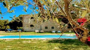 un edificio con piscina frente a un árbol en Exclusive Pool-open All Year-spoleto Biofarm-slps 8-village shops, bar1 km 7 en Poreta