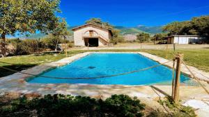 a swimming pool in a field with a building in the background at Exclusive Pool-open All Year-spoleto Biofarm-slps 8-village shops, bar1 km 2 in Poreta