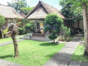 ein Haus mit Garten und Hof mit Rasen in der Unterkunft DATON HOUSE near Bali Zoo Ubud Mitra RedDoorz in Darmasaba