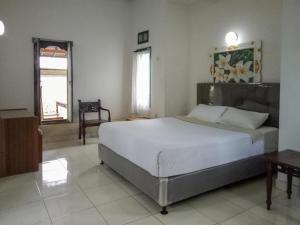 ein Schlafzimmer mit einem großen Bett in einem Zimmer in der Unterkunft DATON HOUSE near Bali Zoo Ubud Mitra RedDoorz in Darmasaba + 17 Fotos