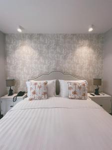a bedroom with a large white bed with two lamps at Hotel Boutique Casa Hendaus - Adults Only in San Andrés