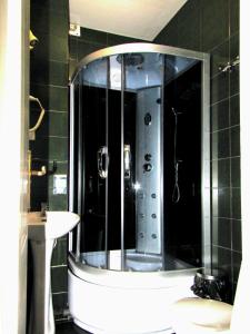 y baño con ducha y espejo grande. en Bella Donna Hotel, en Chişinău