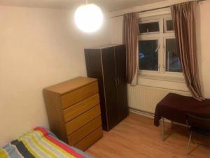 een slaapkamer met een bed, een dressoir en een raam bij Arbnb Comfy Sleep Guest House Self Catering Private Bedrooms 60 pound per night per person in Londen