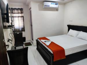 a bedroom with a bed and a television in a room at Hotel Destiny in Visakhapatnam