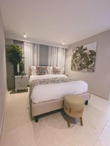 a large bedroom with a large bed and a stool at Hotel Boutique Casa Hendaus - Adults Only in San Andrés