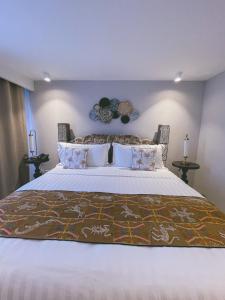 a bedroom with a large bed with white sheets and pillows at Hotel Boutique Casa Hendaus - Adults Only in San Andrés