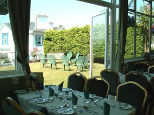 Ashley Court Hotel في توركواي: غرفة طعام بها طاولات وكراسي ونافذة كبيرة