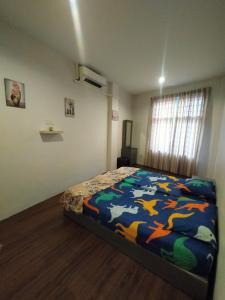 a bedroom with a bed with a colorful blanket at JOKA-JOKA GUESTHOUSE in Melaka