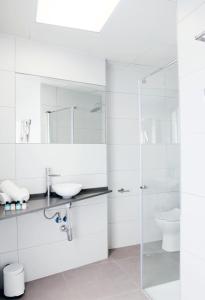 uma casa de banho branca com um lavatório e um chuveiro em San Remo em Alicante