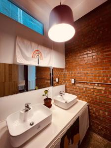 a bathroom with two sinks and a brick wall at 高雄駁二迴埕Return Trip in Kaohsiung