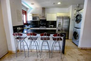 a kitchen with a counter with three stools at Luxury One Bedroom Apartment in the Old City in Cartagena de Indias