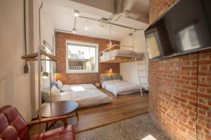 a room with two beds and a brick wall at 高雄駁二迴埕Return Trip in Kaohsiung