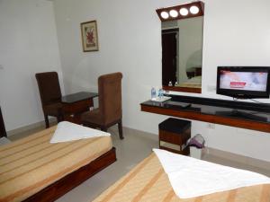 A television and/or entertainment centre at Lotus Comfort - A Pondy Hotel