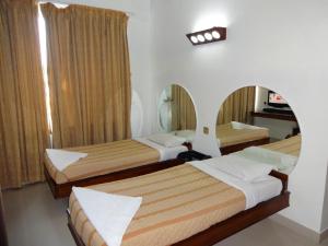 A bed or beds in a room at Lotus Comfort - A Pondy Hotel