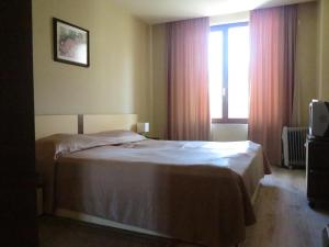 a bedroom with a bed and a window at Krassy summer apartment in Golden Sands