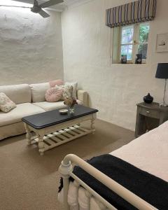 uma sala de estar com um sofá e uma mesa de centro em Fleetwood Cottage Bed and Breakfast em Mylor