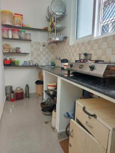 a kitchen with a counter with a stove in it at The coloursinn Home stays in Chennai