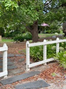 a white fence and a stone walkway next to a tree at Fleetwood Cottage Bed and Breakfast in Mylor +28 photos