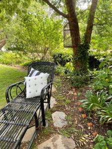 a black bench with a pillow sitting next to a tree at Fleetwood Cottage Bed and Breakfast in Mylor