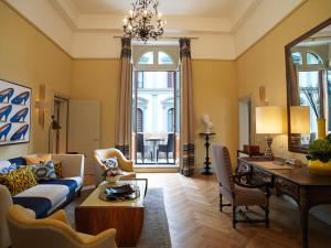 
a living room filled with furniture and a large window at Rocco Forte Hotel Savoy in Florence

