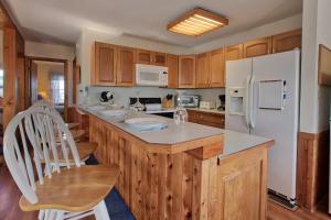 a kitchen with wooden cabinets and a white refrigerator at Victorian Dollhouse 131 in Salvo