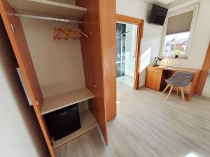 a room with a closet with a desk and a kitchen at Hotel Marqués de Aguilar in Aguilar de Campóo