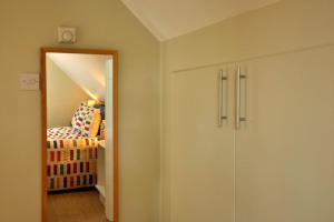 een hal met een deur naar een slaapkamer met een bed bij Trinidad, 45 School Road, Coach House in Birmingham
