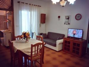 Villetta Paola marina di Ostuni في فيلانوفا دي أوستوني: غرفة معيشة مع طاولة وأريكة وتلفزيون