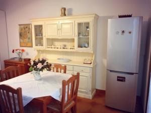 Il comprend une cuisine équipée d'une table et d'un réfrigérateur blanc. dans l'établissement Villetta Paola marina di Ostuni, à Villanova di Ostuni