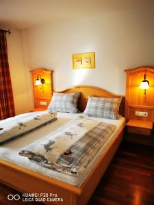 two twin beds in a bedroom with two lamps at Allgäuer Landhaus in Fischen