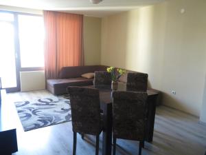 sala de estar con mesa, sillas y sofá en Krassy summer apartment, en Golden Sands