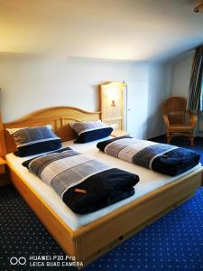 two beds in a hotel room with two bedsvisor at Allgäuer Landhaus in Fischen