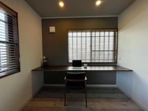 Zimmer mit einem Schreibtisch und einem Laptop darauf in der Unterkunft Hayama Ocean View Villa -葉山 海を見渡す家- in Hayama