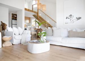 Sala de estar blanca con sofás blancos y mesa en The Noosa Apartments, en Noosa Heads
