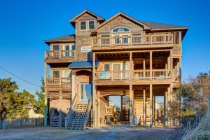 a large wooden house with stairs up to it at Passing Winds 741 in Salvo