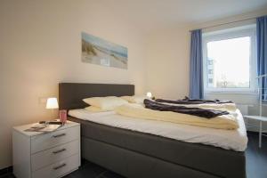 - une chambre avec un grand lit et une fenêtre dans l'établissement Duenenpark-Heiligenhafen-Haus-Meerduene-Wohnung-1-Meerlust, à Heiligenhafen