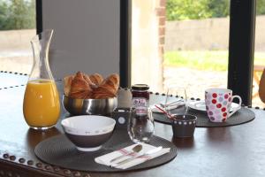 a table with a breakfast of croissants and orange juice at Les Tournelles - Chambres d'hôtes in Saint-Mesmes +26 photos