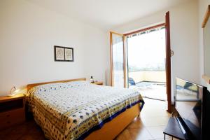 1 dormitorio con 1 cama y puerta corredera de cristal en Casa Orchidea - Vista Mare meravigliosa, en Bonassola